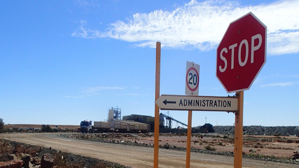 Stop sign on a mine site with plant or mill in the background